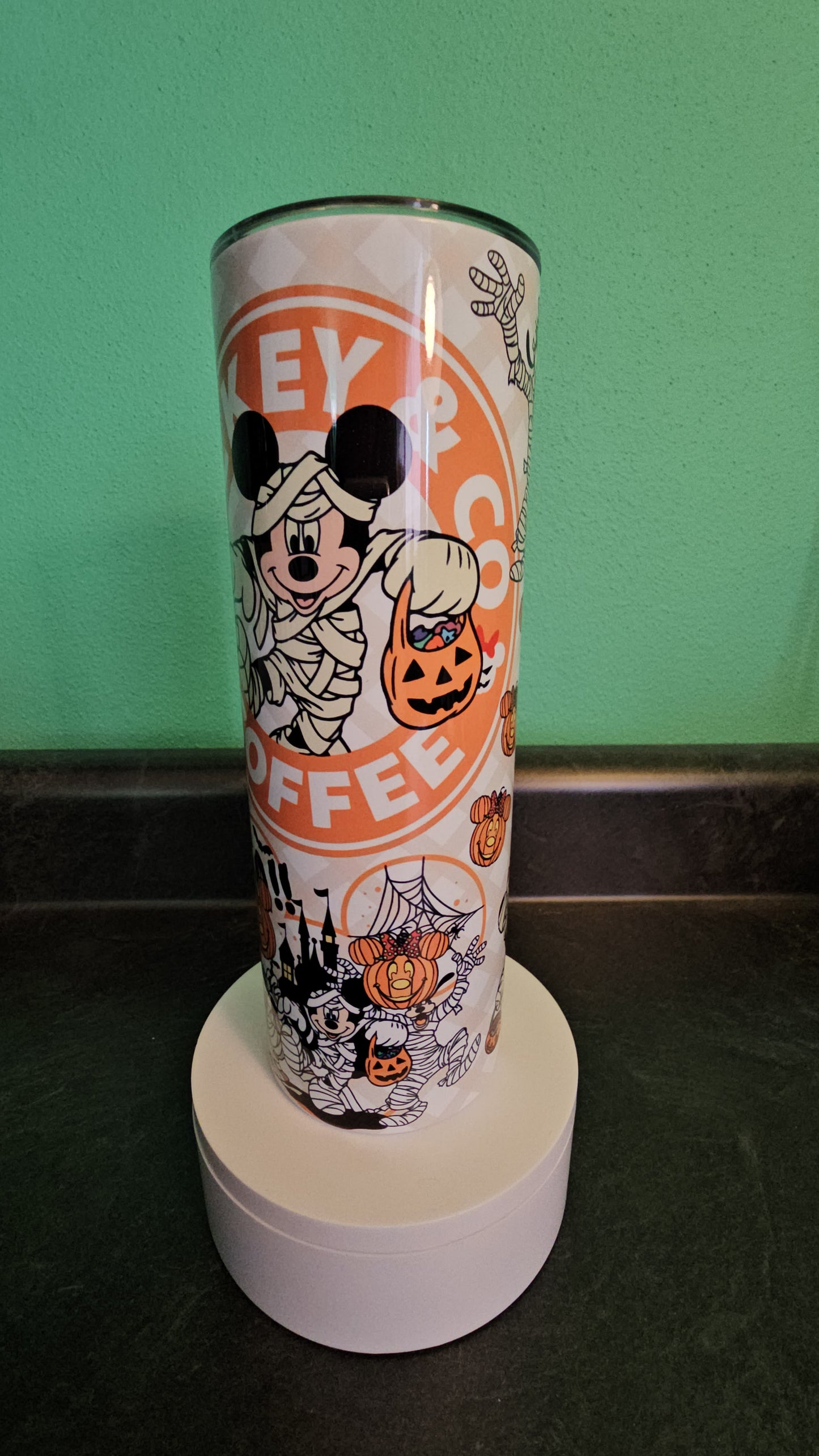 Tumbler with Halloween-themed design featuring Mickey Mouse on a green and black background